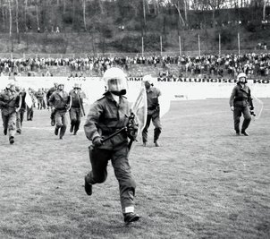 Viel zu spät kommt die Polizei auf das Spielfeld, wo Hooligans Spieler angegriffen haben. 
