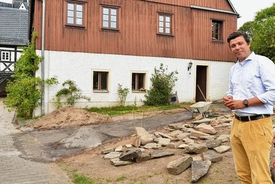 Pfarrer Justus Geilhufe im Herbst 2022 vor dem Pfarrhof mit Pilgerherberge in Großschirma. Dorthin führt am Pfingstmontag die Pilgerwanderung.