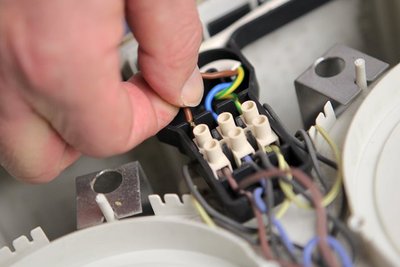 Ein Mann schraubt an einer Kaffeemaschine.