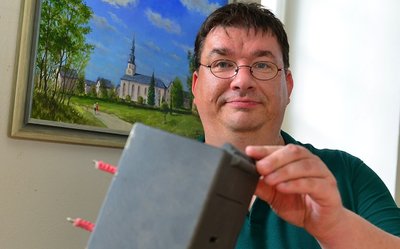 Kirchenvorsteher Michael Kreskowsky zeigt im Vorraum der Kirche in Grünlichtenberg die wieder aufgetauchte Spendenbox. Sie war dort am 31. August aus der Wand gerissen worden.