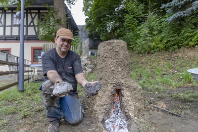 Martin Straßburger zeigt, wie in er Vergangenheit unter einfachsten Bedingungen Eisen geschmolzen wurde.