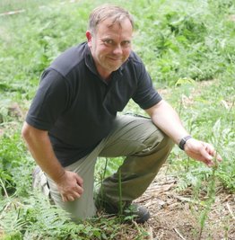 Waldbesitzer Sven Körner neben einer frisch gepflanzten Lärche.
