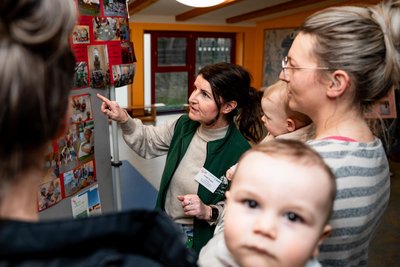 Leiterin Antje Huyer erklärt Silke Böhme, mit Tochter Thea und Luise Dankert, mit Sohn Bruno, das Konzept der Kita „Sonnenkäfer“.