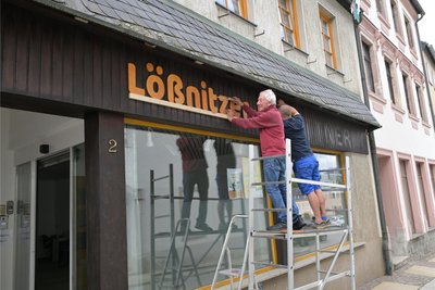 Über dem Eingang ist der Schriftzug „Lößnitzer Bildungsweg“ angebracht – vorn im Bild Klaus Müller vom Verein.