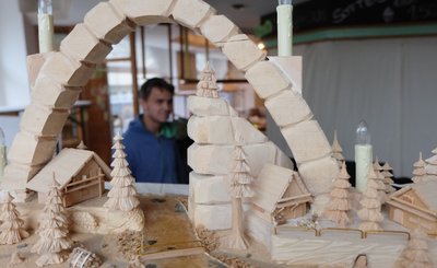 Insgesamt 29 Schwibbogen-Variationen - wie dieses geschnitzte Kunstwerk - sind in den Schaufenstern des Ex-Cafés "Eisbeere" zu sehen. Nils Risterm hat beim Aufbau der Jubiläumsschau geholfen. 