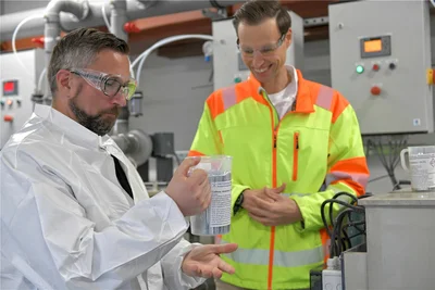 Der Becher hat Gewicht: Wirtschaftsminister Martin Dulig (SPD, links) prüfte am Mittwoch bei der FNE Entsorgungsdienste Freiberg GmbH unter den Augen von Prokurist Martin Seifert eine Galliumprobe, die das Unternehmen am Schachtweg aus Abfällen gewonnen hat. Das Material hat eine Dichte von 5,9 Gramm pro Kubikzentimeter.