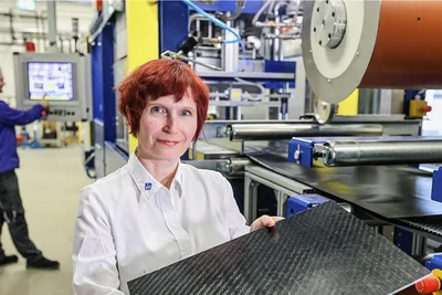 Yvette Dietzel an einer Intervallheißpresse, wo zur Zeit Glasfaser mit Kunststoff verbunden wird. Die entstehenden Organobleche werden als Verstärkungsstrukturen in Verkleidungen genutzt.