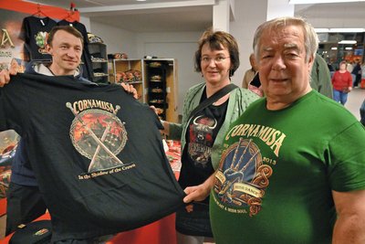 Bei Lars Golbik (l) versorgen sich Bernd und Susanne Braune mit einem Fan-T-Shirt.