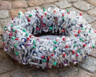 Ein Adventskranz, an dem sich die Geister scheiden. Rund sechs Stunden Arbeitszeit sowie 600 sterilisierte Impfampullen und Spritzen stecken in der ungewöhnlichen Weihnachtsdekoration. 