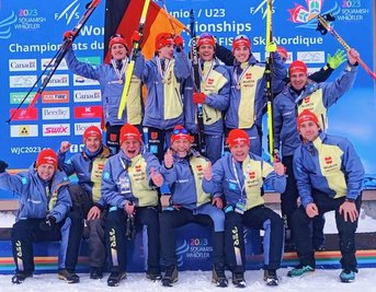 Die jubelnde Kombinierer-Mannschaft zur JWM 2023 in Whistler. Mit dabei die Goldgewinner Pepe Schula (oben links) und Tristan Sommerfeldt (oben rechts) sowie ihr Trainer Frank Erlbeck (unten, 3. von links). 