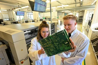 5G-Nutzung ohne China? Hartmannsdorfer Firma macht es vor und will Umsatz verdreifachen - Mitarbeiterin Saskia Pfeil und Azubi Vincent Pehns kontrollieren eine Leiterplatte für Telekommunikationsgeräte, die in Hartmannsdorf bestückt wird.