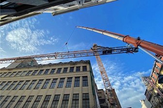 60 Meter langer Kranausleger schwebt durch Zwickauer Hauptstraße - Behutsam wird der Kranausleger direkt neben dem Schocken-Kaufhaus in die Höhe bugsiert.