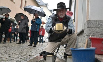 Gunther Demnig beim Verlegen der Stolpersteine vor dem Haus in der Rudolf-Weber-Straße 6. 