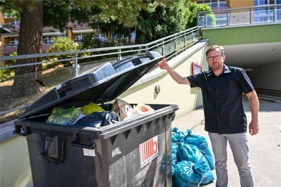 Dirk Stimming vom Wohnpark Lindenhof zeigt auf die volle Restmülltonne, die in dieser Woche nicht abgeholt wird.