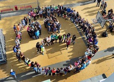 An der Oberschule in Hainichen haben sich die Schülerinnen und Schüler aller Klassenstufe auf dem Schulhof ein sogenanntes trauriges Smiley gebildet.