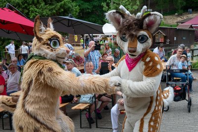 Die Maskottchen Selly und Parpar tanzen zur Livemusik vom Brass-Swing-Orchester.