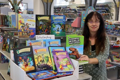Katrin Otto von der Bahnhofsbuchhandlung hat ein Regal mit Büchern aus der Reihe „7-Minuten-Geschichten zum Lesenlernen“ zusammengestellt.