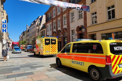 Rettungswagen und Notarztfahrzeuge vor der Postbank.