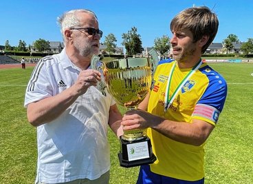 Staffelleiter Horst Stein (links) übergibt den Meisterpokal an RFC-Kapitän Mirko Hendel. 