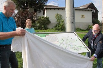 600 Jahre: Wie der zu Elsterberg gehörende kleine Ort Scholas sein Ortsjubiläum begeht - Ortsvorsteher Uwe Pansa, die Vorsitzende der Dorfgemeinschaft, Mona Glück, Bürgermeister Sandro Bauroth (von links) enthüllten die neue Ortstafel. 