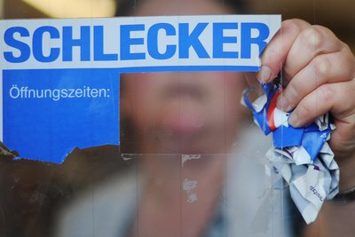 Hannover, im März 2012: Eine Schlecker-Mitarbeiterin entfernt das Firmenlogo von der Eingangstür einer Filiale.