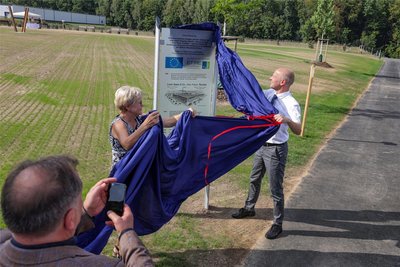 Kerstin Götze und Bürgermeister Jörg Schmeißer enthüllen die Info-Tafel am Park.