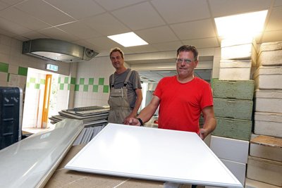 Tischler Ben Löffler (li.) und Elektriker Andreas Bieler statten zurzeit im Auftrag der Gemeinde die Decke der Schulküche mit LED-Beleuchtung aus. Das soll Betriebskosten senken.