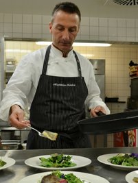 Wenn schon Gemüse, dann mit Beilage: Der Brandenburger Chefkoch Matthias Kleber garniert einen Salat mit gebratener Forelle.