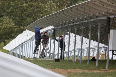 An einer Autobahn werden Solarmodule installiert.