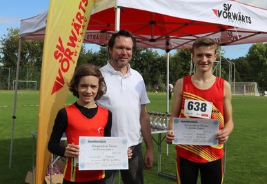 Der stellvertretende Vorsitzende des SV Vorwärts Zwickau, Stefan Bausch (Mitte), und die Lauf-Talente Jeremias Hertel (links) und Noah Rölle (rechts) mit den Spendenschecks. 