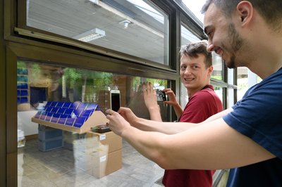 Schaulustige fotografieren durchs Schaufenster in den Laden.