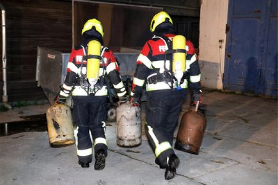 Kameraden der Freiwilligen Feuerwehr Oberlichtenau beim Entfernen von Gasflaschen, die sich an der Brandstelle befanden.