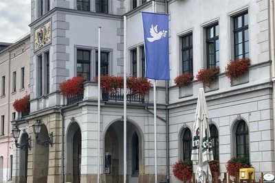 Vor dem Oelsnitzer Rathaus hängt die Friedenstaube. Angestoßen hat das die örtliche Buchhändlerin Kathrin Jakob.