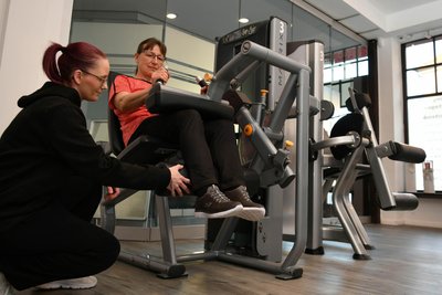 Karin Discher beim Training mit dem Beinbeuger. Claudia Benicke ist eine der Trainerinnen.