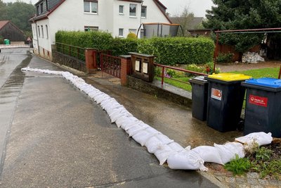 Die Anwohner versuchen, ihre Grundstücke mit Sandsäcken vor den Wasser- und Schlammmassen zu schützen.