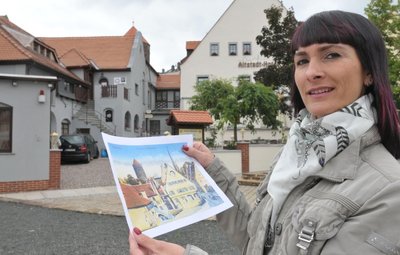 Christine Walcha führt das neue Altstadt-Hotel an der Donatsgasse in Freiberg. Hier hält sie eine historische Aufnahme von dem Haus, die auch als Ansichtskarte erhältlich ist.