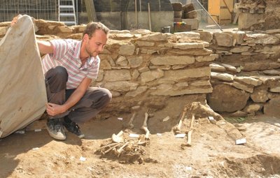 Vor einer frei gelegten Mauer zeigt Grabungsleiter Matthias Schubert auf dem Grünen Friedhof des Freiberger Doms Grabstellen.