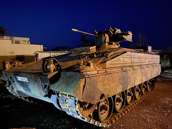 Ein Panzer Marder und ein gepanzertes Fahrzeug standen vor dem Sportplatz.