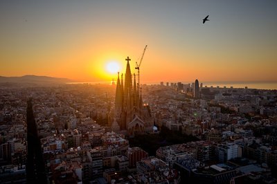 Im Gegenlicht der aufgehenden Sonne ist das Kreuz aus Deutschland auf der Spitze des höchsten Turms der Basilika Sagrada Família in Barcelona gut zu erkennen. (Archivbild)