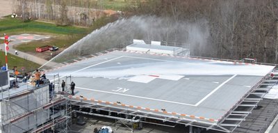 Schaum aus der Löschlanze: Eine Feuerlöschübung am Hubschrauberlandeplatz fand im April 2021 statt - lange vor der Inbetriebnahme. Links hinten im Bild die bisherige Heli-Landestelle.