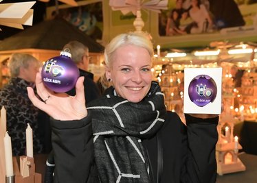 Besucherin Romy Lorenz aus Oelsnitz hält die neue FCE-Weihnachtskugel in Händen. 