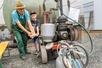 In Berbersdorf trafen sich wieder die Technikfans. Roland Gruhle aus Berbersdorf mit Vince (9) aus Annaberg vor einer Melkmaschine.