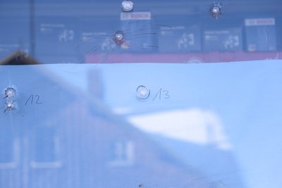 Einschusslöcher in einer Fensterscheibe des Geschäfts.