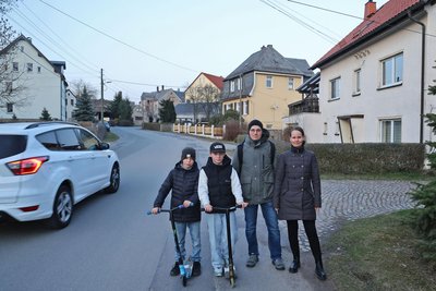 Familie Bodenschatz macht sich stark für den Ausbau der Oberlungwitzer Straße, im Bild Markus und Daniela Bodenschatz mit Sohn Noah (links) und dessen Freund Fritz Kleiber: Sie (und viele andere) hoffen auf einen Fußweg. Doch das Straßenbau-Projekt ist gefährdet.