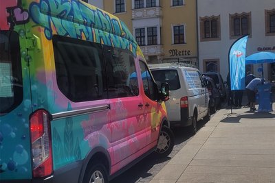 Der bunte „Katapult“-Wagen am Obermarkt Freiberg. Nur wenige Meter weiter wirbt die AfD um Wählerstimmen.