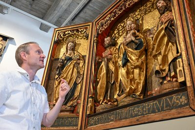 Stefan Thiele vor dem Flügelaltar aus Vielau, um 1515 von Peter Breuer geschaffen.