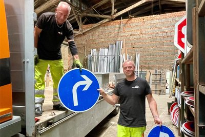 Kay Meinel (l.) und Johannes Schefel, Mitarbeiter der Firma VT-Erz, beim Abladen nicht mehr benötigter Hinweisschilder. Sie wandern vorerst wieder ins Regal.