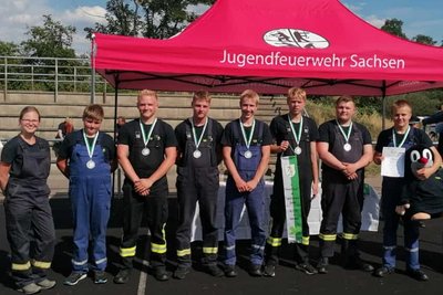 Jugendwartin Sandra Muster (von links) bei der Siegerehrung mit Florian Heister, Leif Kaschner, Yanick Pfeiffer, Peter Sarodnik, Pascal Wissuwa, Niclas Steiner und Luca Thomas mit dem Maulwurf-Maskottchen der Jugendfeuerwehr Oberschöna.