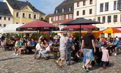 Unterm Sonnenschirm sitzen, genießen und sich unterhalten.