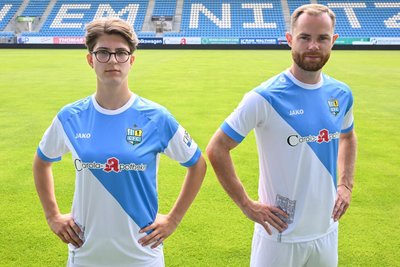 Amelie Bär und Tobias Müller präsentieren das neue Heim-Trikots des CFC. Bär wird allerdings nicht darin spielen, die Dresse gibt es nur für die Männermannschaft. An der rechten Hand von Tobias Müller ist das besondere Detail zu sehen: ein Flutlichtmast der „Fischerwiese“.